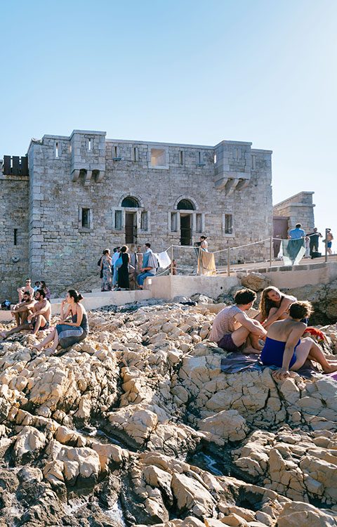 gens en train de prendre le soleil sur les roches de l'île degaby